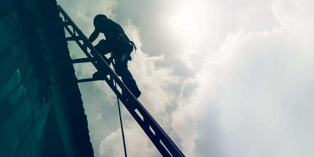 photo of a man cleaning gutters on a ladder